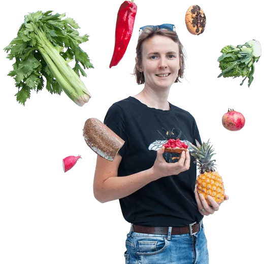 Femme avec friuts, légumes et cookie autour d'elle