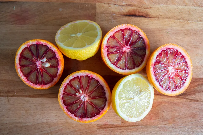 Planche avec oranges sanguines et citrons coupés en deux