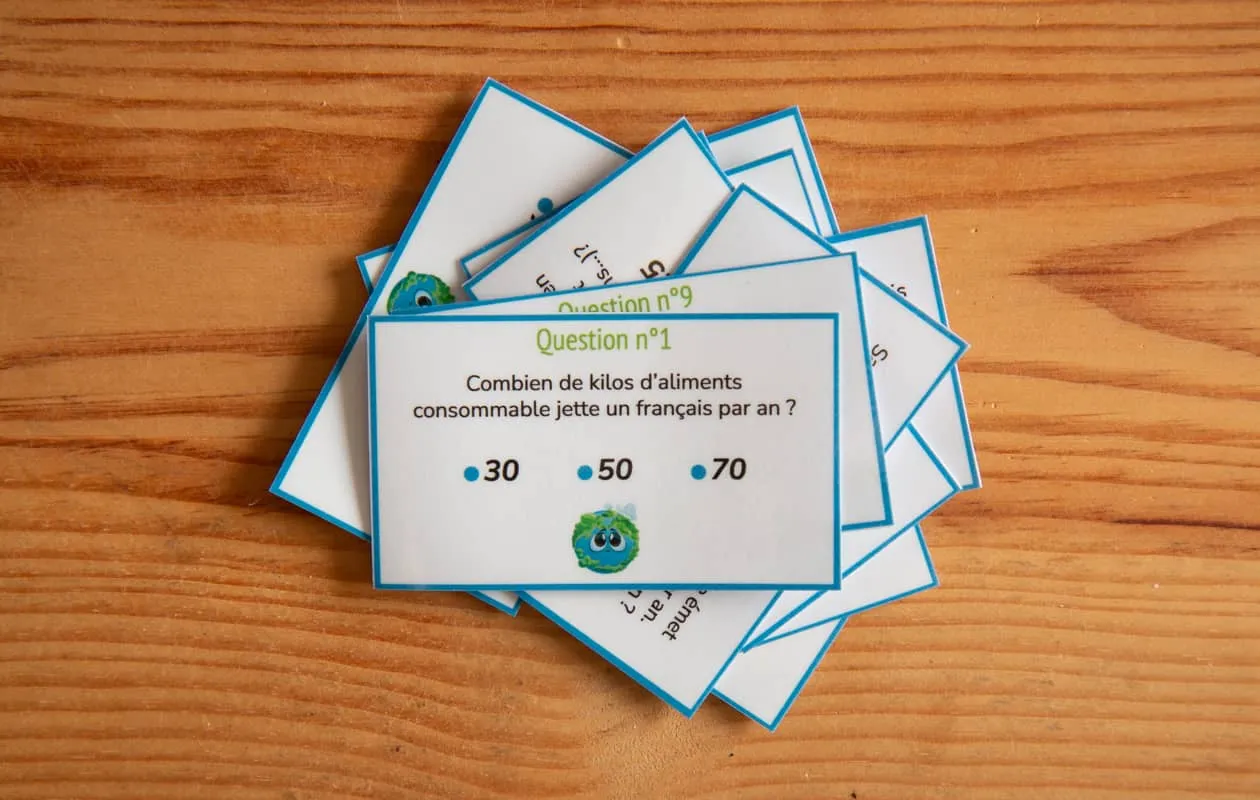 10 cartes quiz sur le thème de l'alimentation et de l'écologie posées sur un bureau en bois